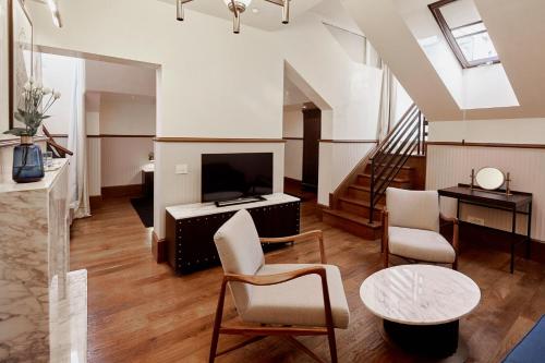 a living room with a tv and a table and chairs at Callas House in Budapest