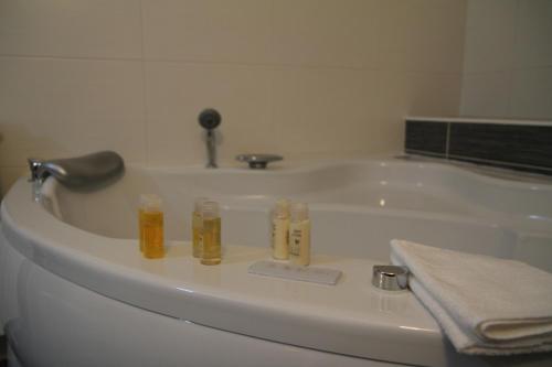 a bathroom with a bath tub with three bottles at Hotel Trebjesa in Nikšić