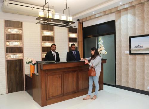 a woman standing in front of a reception desk at Civic Inn in Dhaka