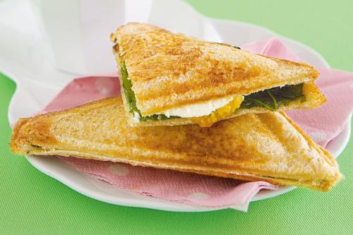 Un sándwich se corta por la mitad en un plato en Bay View House, en Padangbai