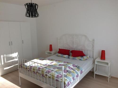 a bedroom with a white bed with red pillows at apartma Delavska in Maribor