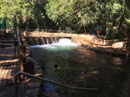 a bridge over a river with a waterfall at Paradise Rio Quente 517 in Rio Quente