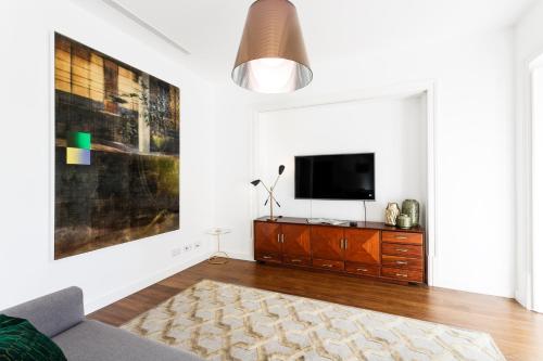 a living room with a tv on a white wall at Chalet Estoril Luxury Apartments in Estoril