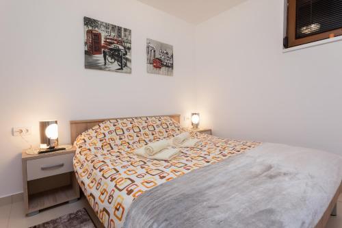 una camera da letto con un letto con due comodini e due lampade di Astra Apartment a Zlatibor