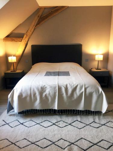 une chambre avec un grand lit blanc avec deux lampes dans l'établissement Km 41, à Chaumont-sur-Tharonne