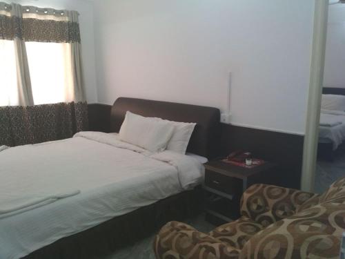 a bedroom with a bed and a table with a window at Sai Pavilion in Puttaparthi