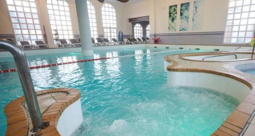 une grande piscine avec de l'eau bleue dans un immeuble dans l'établissement Studio *** 