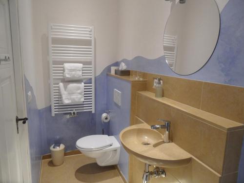 a bathroom with a toilet and a sink and a mirror at Im Bahnhof - Gästezimmer - in Weikersheim