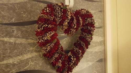 a red heart shaped wreath on a wall at Casa Mafalda in Chioggia