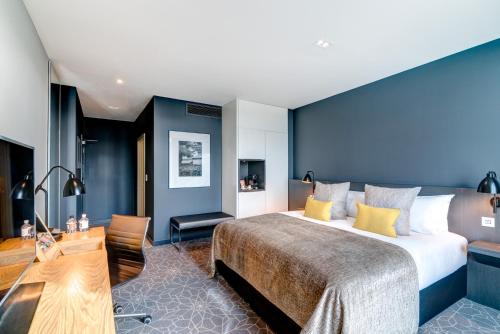 a hotel room with a large bed and a desk at Apex City of Bath Hotel in Bath