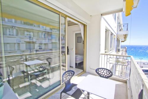 un balcon avec une table et des chaises et l'océan dans l'établissement PROMENADE HOLIDAY - PALATIN & SEA, à Nice