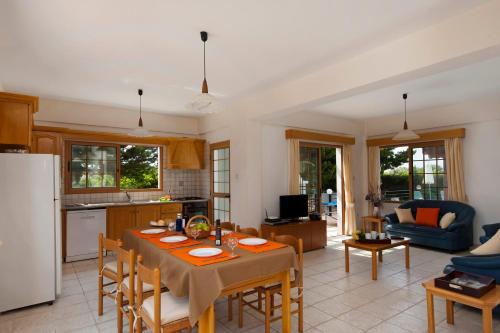 a kitchen and living room with a table and chairs at Panareti Coral Bay Villas in Coral Bay