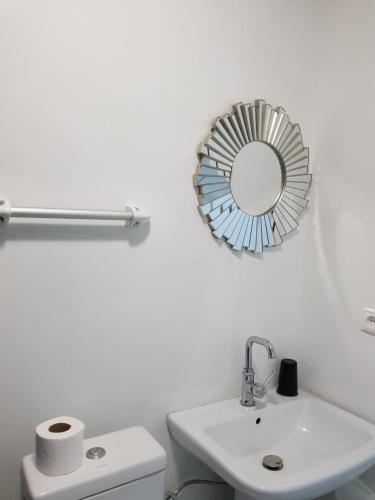 a bathroom with a sink and a mirror on the wall at Ossanzaia Bilene Lodge in Vila Praia Do Bilene