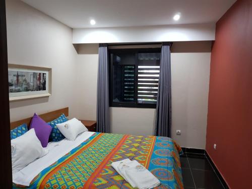 a bedroom with a bed and a window at Ossanzaia Bilene Lodge in Vila Praia Do Bilene