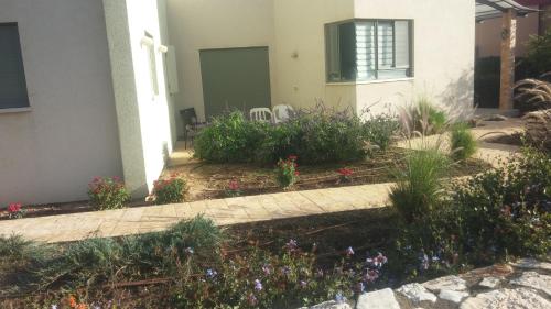 a garden in front of a house with flowers at Holiday home in Galilee in Sheʼar Yashuv