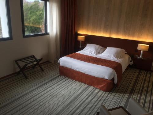 a bedroom with a large bed in a hotel room at Hotel du Casino in Saint-Valéry-en-Caux