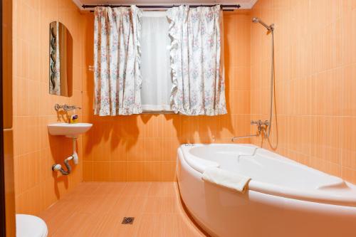 baño de color naranja con bañera y lavamanos en Everest, en Ivano-Frankivsk