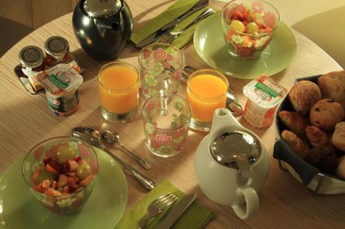 a table with plates of food and glasses of orange juice at Le César Hôtel in Provins