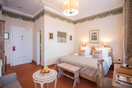a hotel room with a bed and a table at Hotel Der Kleine Prinz in Baden-Baden