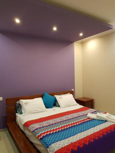 a bedroom with a bed with a colorful quilt on it at Ossanzaia Bilene Lodge in Vila Praia Do Bilene