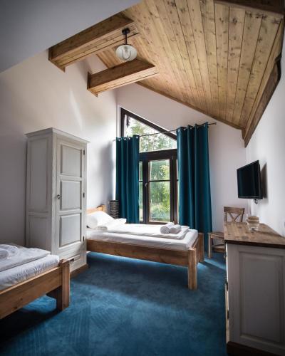 a bedroom with two beds and a large window at DWÓR U PAPUGA in Ruciane-Nida