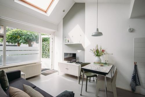 een woonkamer met een tafel en een raam bij Kranenbergh Boutique Apartments in Bergen