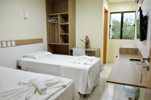 a hotel room with two beds with white sheets at Hotel Recanto Vip - Antigo Recanto da Serra in Araripina