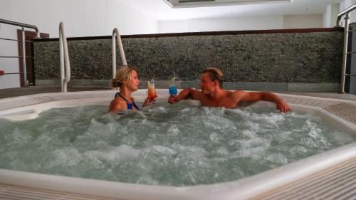 a man and woman sitting in a jacuzzi tub at Cleopatra Luxury Resort Makadi Bay in Hurghada