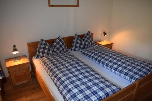two beds in a bedroom with blue and white pillows at Residence Miragolf in Madulain