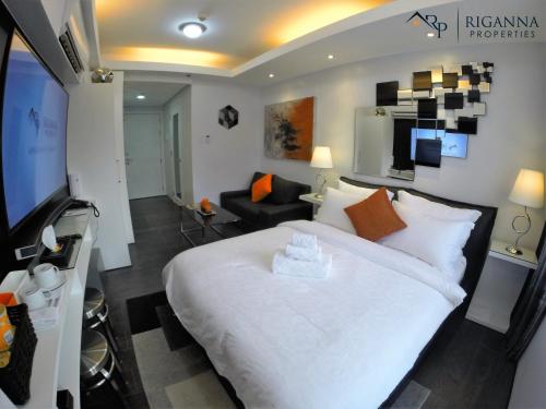 sypialnia z dużym białym łóżkiem i telewizorem w obiekcie Riganna Two @ Shell Residences - near Airport, MOA w mieście Manila