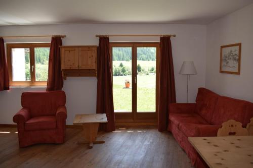 a living room with a red couch and a window at Residence Miragolf in Madulain