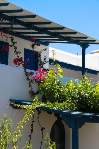 a balcony with flowers on the side of a building at Maroussa Studios in Agia Anna Naxos