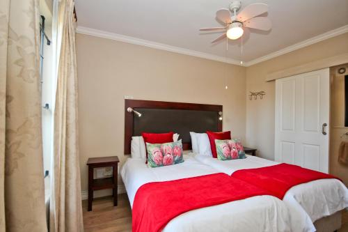 a bedroom with a large bed with a red blanket at Vilaroux in Stellenbosch
