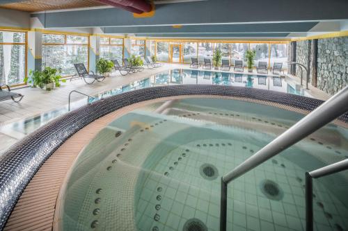 an indoor pool with a hot tub in a building at Panorama Hotel Turracher Höhe in Turracher Hohe