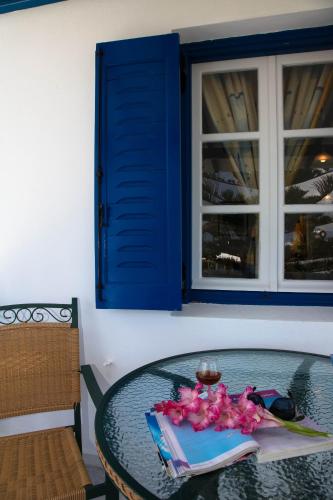 a glass table with pink flowers on top of it at Maroussa Studios in Agia Anna Naxos