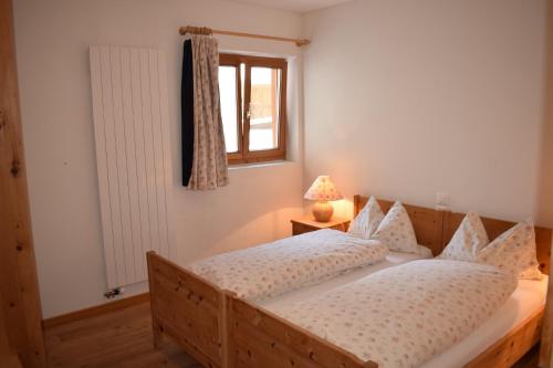 a bedroom with a wooden bed and a window at Residence Miragolf in Madulain
