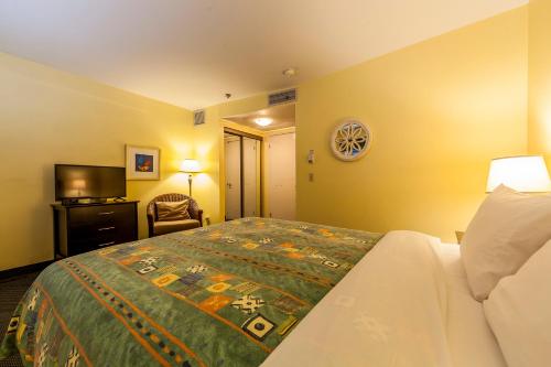a hotel room with a bed and a flat screen tv at Auberge de La Fontaine in Montréal