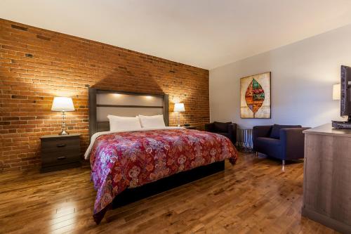 a bedroom with a bed and a brick wall at Auberge de La Fontaine in Montréal