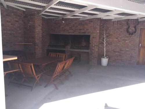 a patio with a table and chairs and a fireplace at White House Lodge On Main in Beaufort West