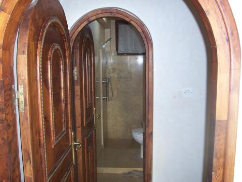 a bathroom with a wooden door leading to a toilet at Taghazout Beach in Taghazout