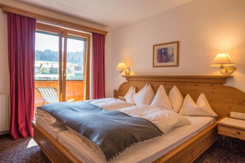 a bedroom with a large bed and a large window at Appartements Spullersee in Lech am Arlberg