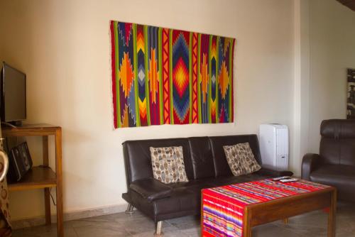 a living room with a couch and a painting on the wall at The Cottages by the Sea in San Clemente