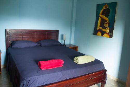 a bed with a red pillow and two towels on it at The Cottages by the Sea in San Clemente