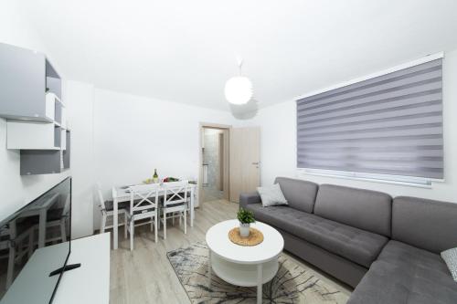 een woonkamer met een bank en een tafel bij Apartman Centar in Banja Luka