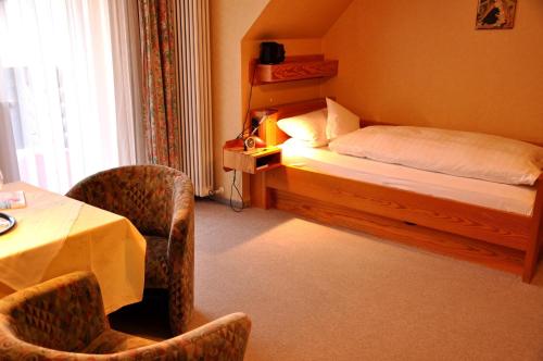 ein Hotelzimmer mit einem Bett, einem Tisch und Stühlen in der Unterkunft Hotel Schick in Bad Wörishofen