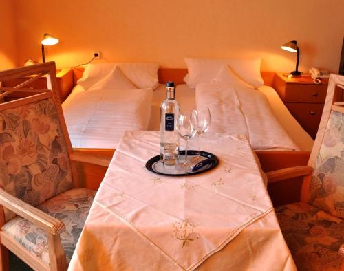 a table with a bottle and two glasses on it at Hotel Schick in Bad Wörishofen