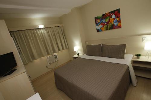 a hotel room with a bed and a television at klein Ville Esteio Br in Esteio