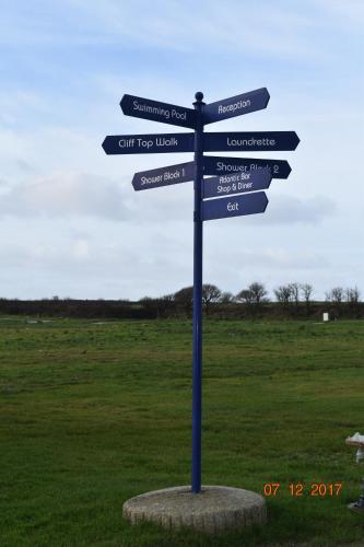 a blue street sign with signs in a field at The Pearl in Bude