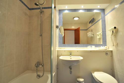 a bathroom with a sink and a toilet and a shower at Campanile Hotel Murcia in Murcia