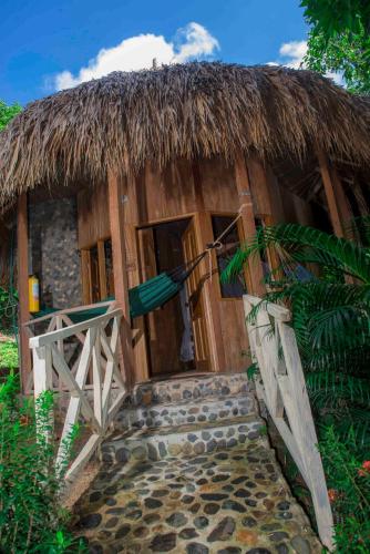 a small hut with a thatched roof and a staircase at Posadas Ecoturisticas Seineken in El Zaino